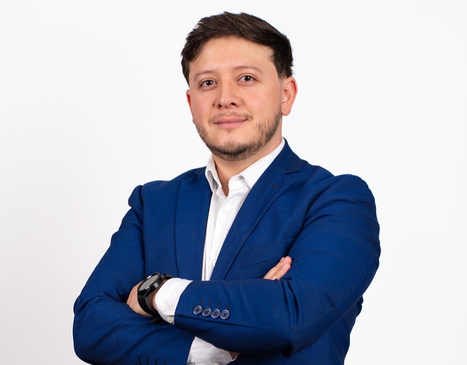 Retrato de estudio de un profesional con saco azul y brazos cruzados